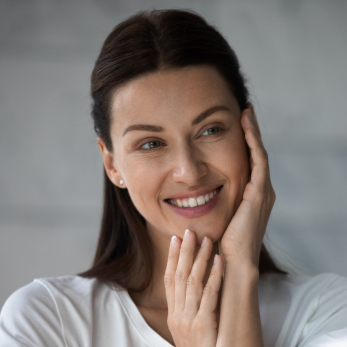 brunette woman in 40's hands on face